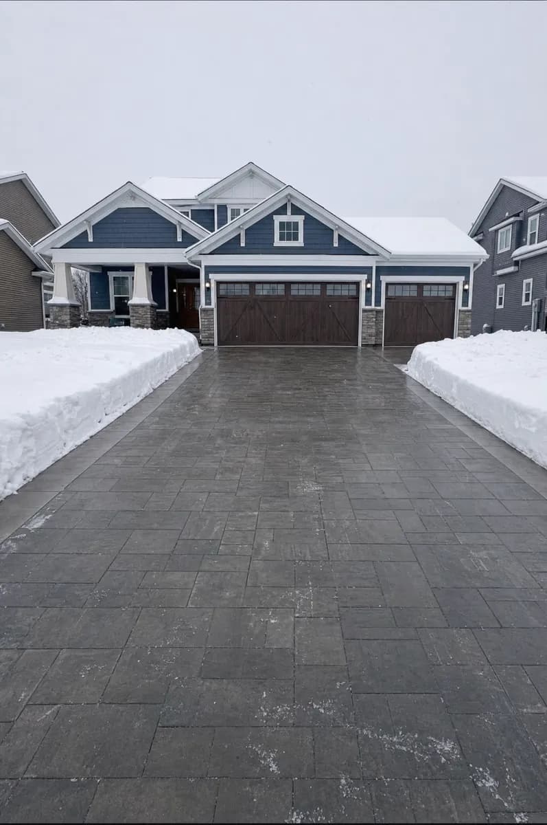 A paver driveway cleared edge to edge after a snowfall